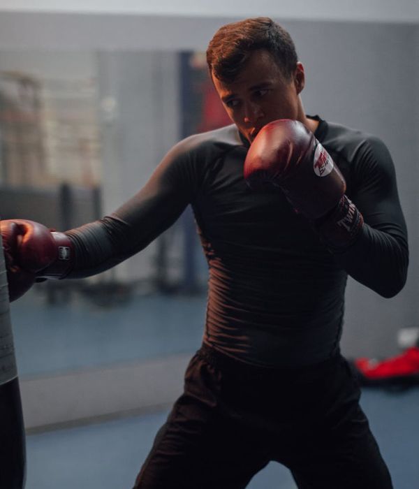 Person looking refreshed and energetic after a workout, standing by a window.